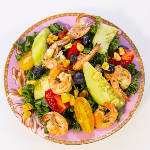 Ensalada de col rizada, amaranto, pepino, tomates cherry, arándanos y aderezo de menta y fresa